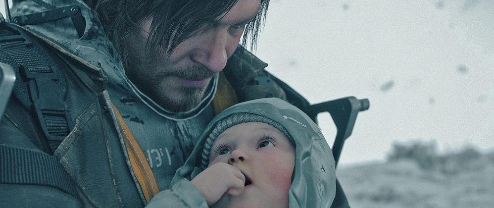 A screenshot from Death Stranding 2 shows Norman Reedus cradling an adorable little baby wearing a nice warm hat.