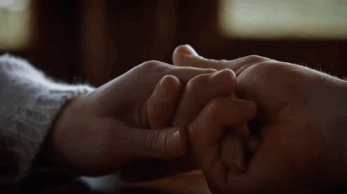 A screenshot from The Leftovers that's a closeup on Nora and Kevin holding hands