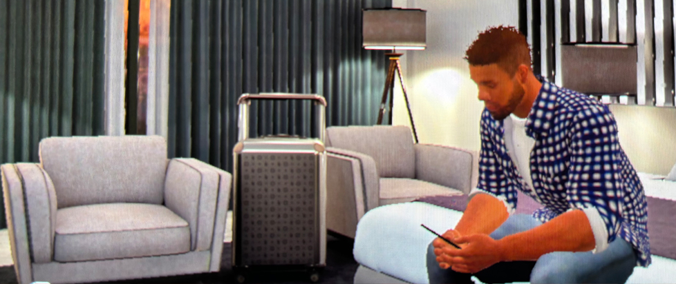 A screenshot from MLB: The Show 25 showing Matt Marrone's player avatar sitting on the couch, staring at his phone. Art imitates life.