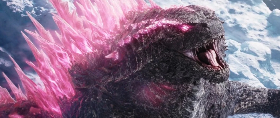 A still from GODZILLA X KONG shows a roaring Godzilla with spikes of pink atomic energy erupting from his head and back.