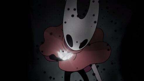 an image from Hollow Knight Silksong, a closeup on Hornet in Red holding a glowing flower and staring at it intently