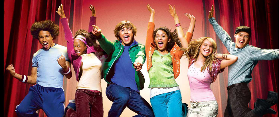 Poster art for High School Musical, featuring a group of teenagers leaping in front of red stage curtains, frozen in mid-air with huge smiles plastered on their faces.