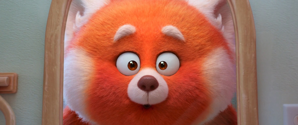 A close-up on the adorable face of the red panda from Pixar's Turning Red, looking at herself in a mirror.