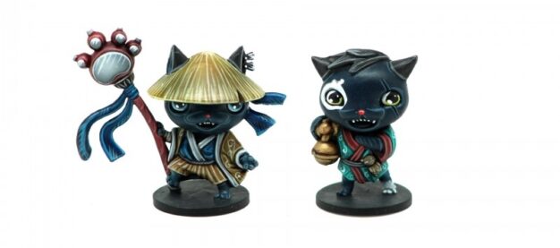Two cat neko minatures for Yokai Quest, both are mostly black cats in traditional japanese robs and one carries a bell and another wears a hat and holds a staff with a cats paw on top