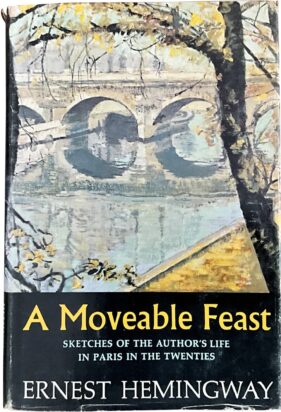 An early cover of Ernest Hemingway's 'A Moveable Feast,' featuring a stone bridge stretching across a river.