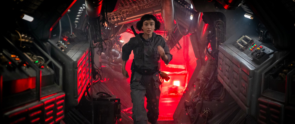 Wendy runs through the red-lit bowels of a crashed spaceship in this still from Alien: Earth.
