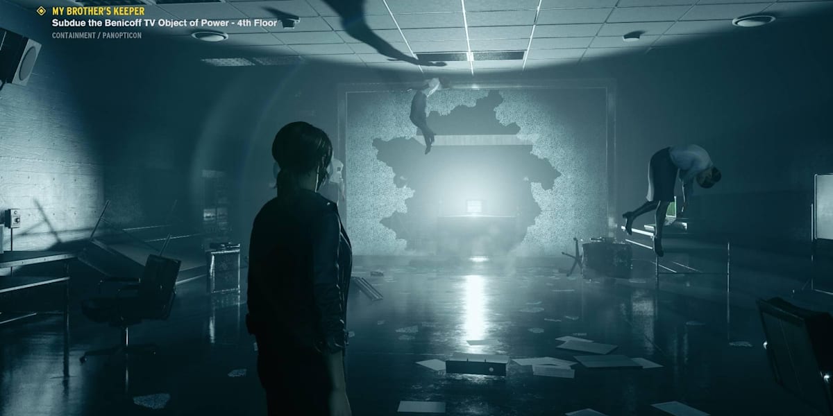 Another Control screenshot has as Jess facing an opening in the brick wall of a darkened office building.