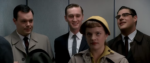 a screengrab from Man Men where Peggy is in an elevator with various dudes from the firm and she's wearing a yellow hat and a look of disdain