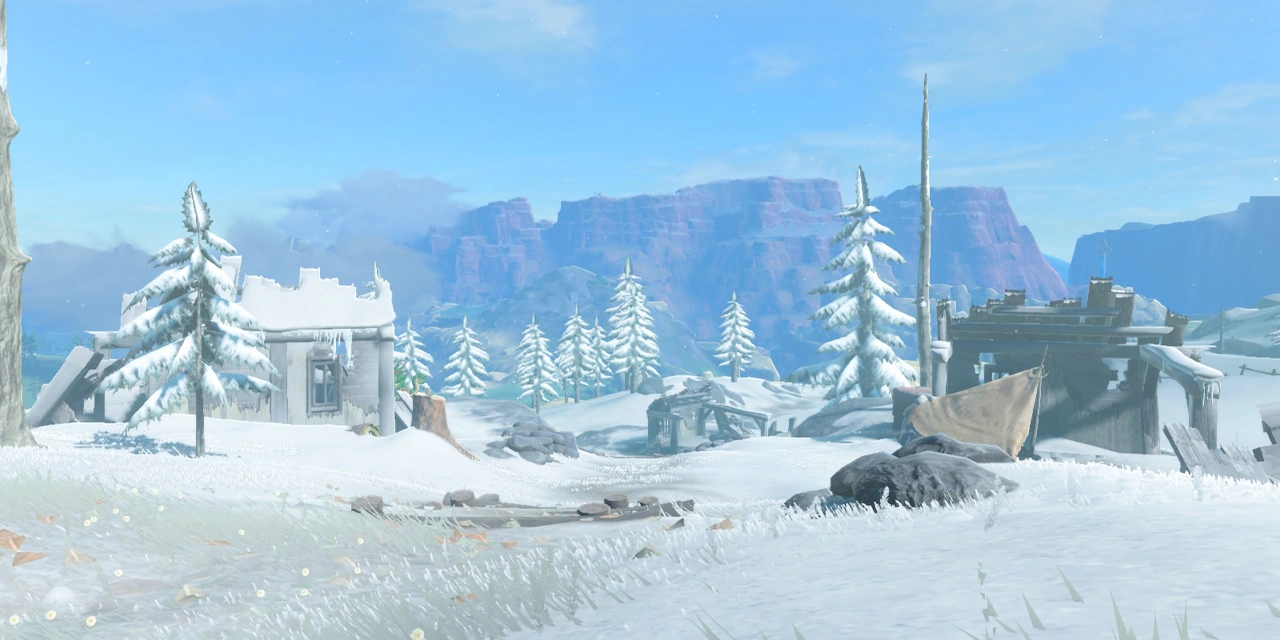 The ruins of two small structures rest, snow-covered, among pine trees and rocky deposits.