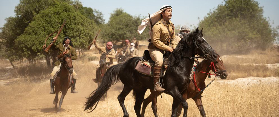 A scene from Palestine 36 shows several men riding through an arid landscape on horseback.