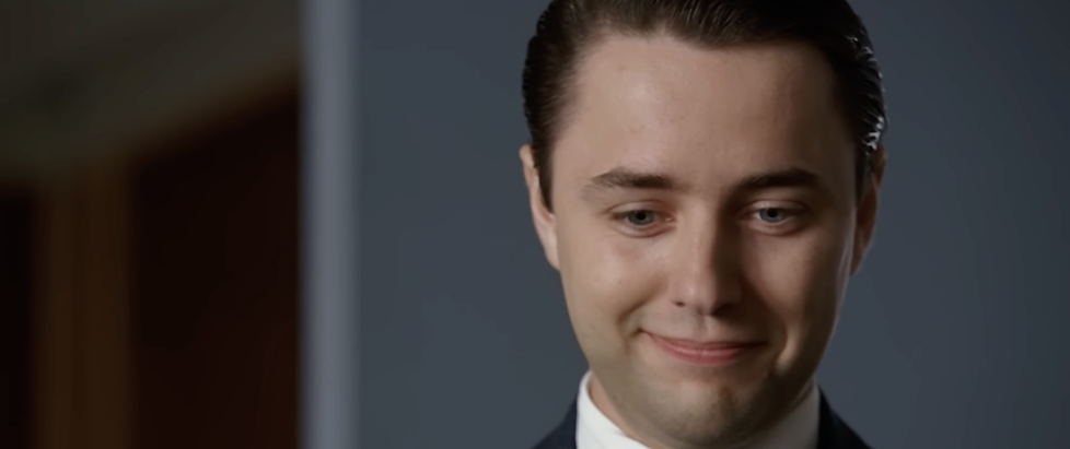A screenshot from Mad Men where Pete is looking down with a little shit eating grin on his face but it might have been an awkward grab who can say