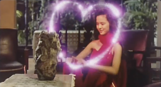A screenshot from the trailer of Saga of the Phoenix where a young demon is making a pink magic heart while talking to her little demon friend