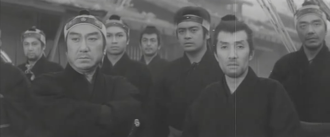 A screenshot from 13 Assassins where a group of them dressed in black look past the viewer with concern