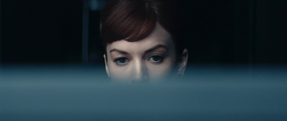 A blurred object in the foreground covers the lower half of Helena Egan's face in a scene from Severance, leaving only her eyes and perfectly coiffed hair visible.