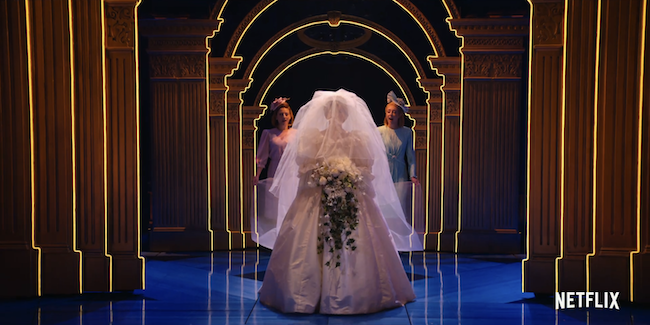 A screenshot from the Netflix trailer for Diana where Diana is wearing a white wedding dress coming down an aisle of lights