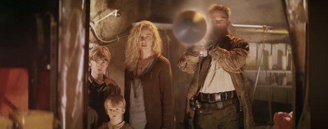 A screenshot from the trailer for Soldier where Kurt Russel is standing next to a woman and two kids and he just fired a rocket directly at the camera WATCH OUT
