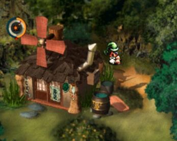 A screenshot from Moon shows a character standing outside a house with a large windmill on the roof in a forest clearing.
