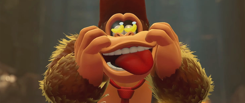 A screenshot from Donkey Kong Bonanza has Donkey Kong holding his cheeks while making a goofy face, miniature bananas dancing in his eyes.