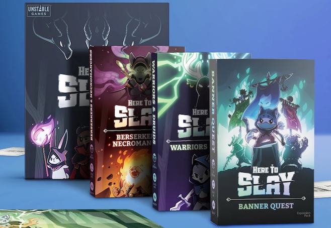 A photograph of the deluxe boxes for Here to Slay with all the animal adventurers in cute glowing cartoon art