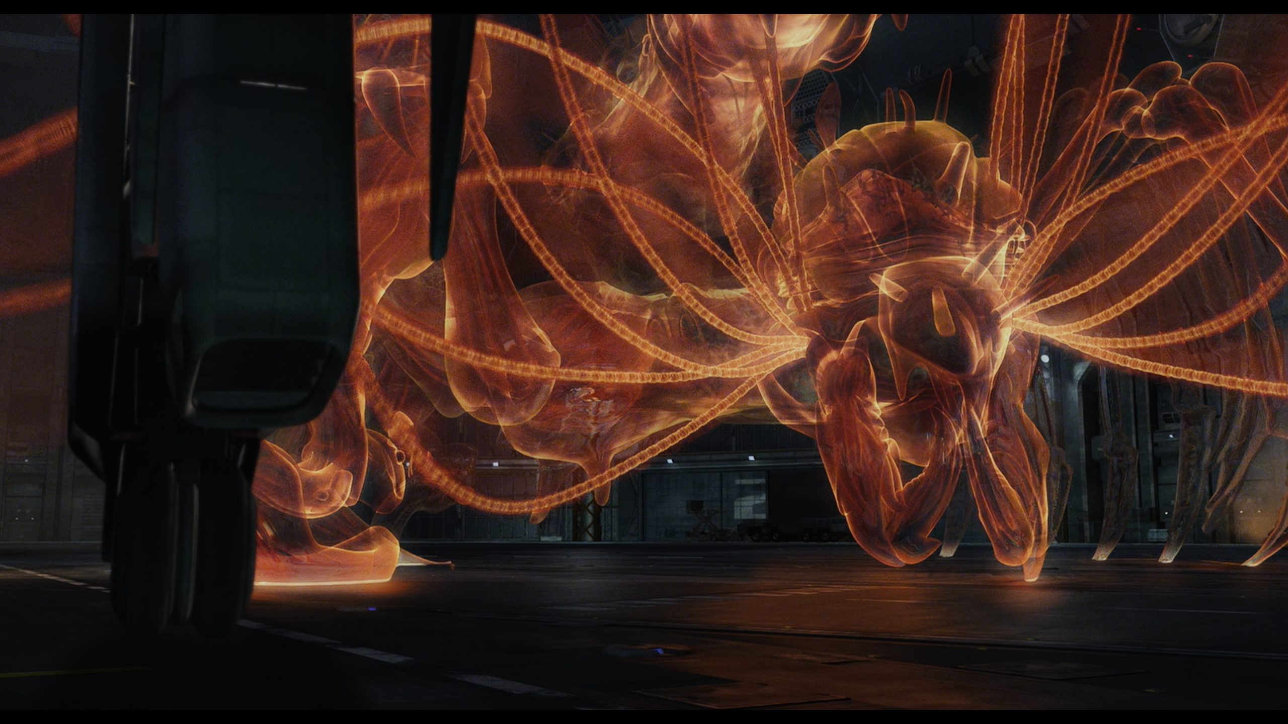 A translucent, glowing orange Phantom from The Spirits Within. It has a complex, somewhat biomechanical or insectoid form with numerous thin, ribbon-like tentacles or energy filaments extending from its body.