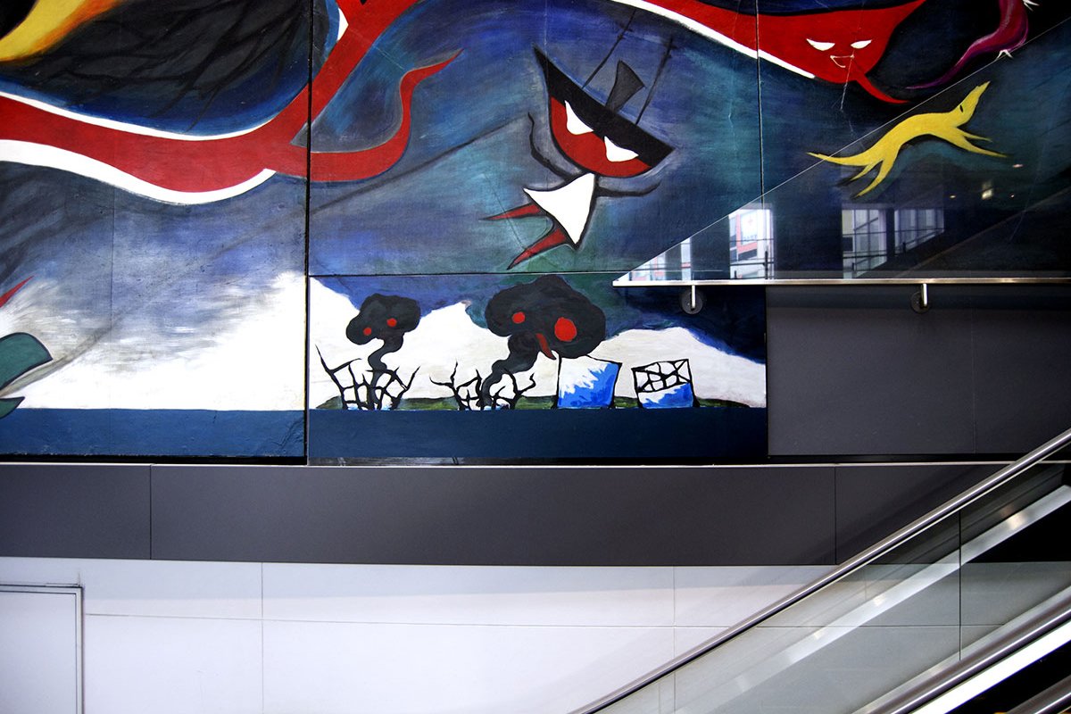 Detail of the large-scale mural "Myth of Tomorrow" (1969) by Japanese artist Tar? Okamoto, located in Tokyo's Shibuya Station. In the lower center, a small panel – a 2011 guerrilla art addition by the collective Chim?Pom titled "Level 7" – is visible. 
