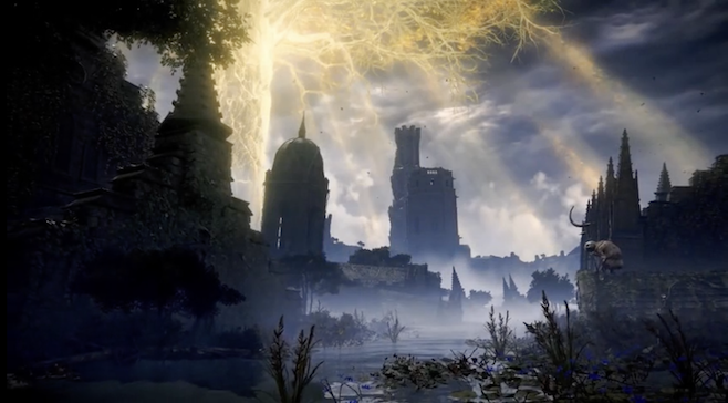 A screenshot from the trailer for Elden Ring with the golden elden tree in the background shining on old towers and mountains covered in fog