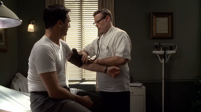 A screenshot from Mad Men where Don is at the Doctor who is taking his blood pressure very seriously
